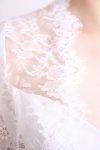 Femme en robe de mariée habillée d'une cape en dentelle de calais