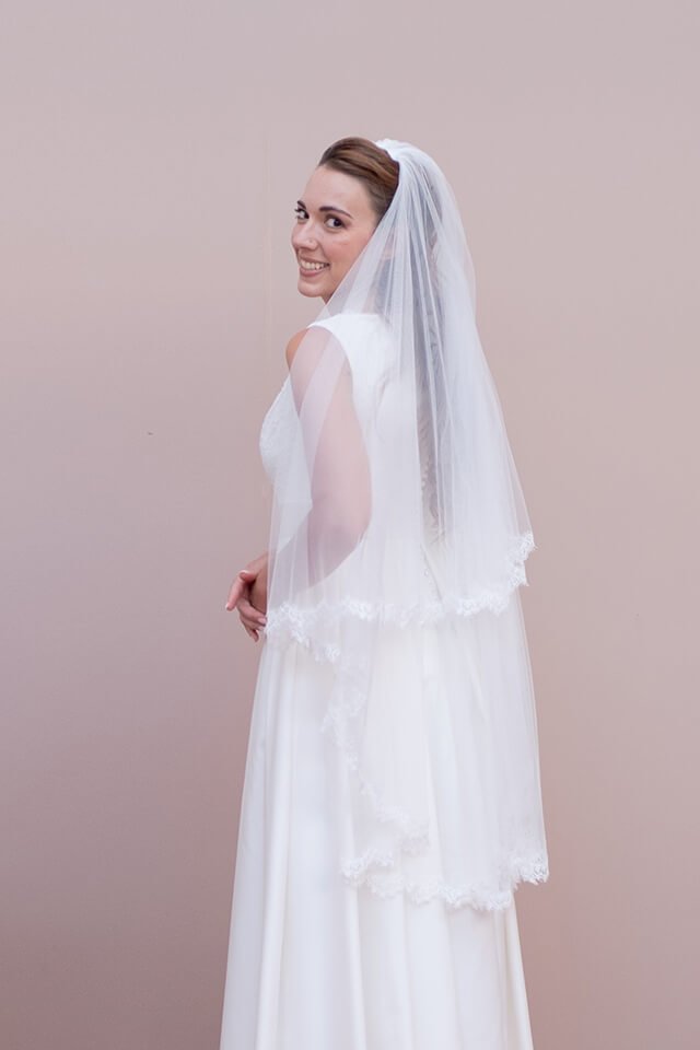 Jeune mariée portant une robe en dentelle et un voile long en tulle et dentelle