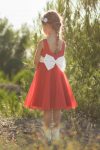 Petite fille en robe de cortège rouge et blanche en crêpe et tulle