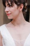Jeune mariée portant un collier et des boucles d'oreilles longues en pierres naturelles rose quartz
