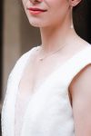 Jeune mariée portant un collier et des boucles d'oreilles longues en pierres naturelles perles