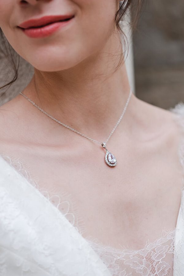 Jeune mariée portant un collier long en forme de goutte en argent et strass