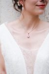 Jeune mariée portant un collier et des boucles d'oreilles en formes de goutte gold rose et strass