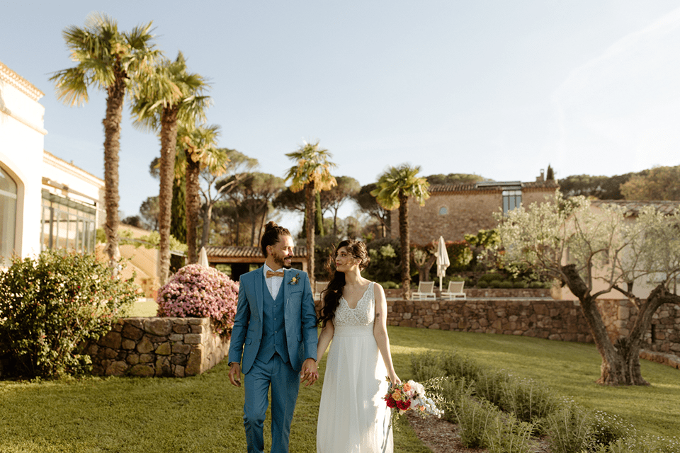 Couple de mariés marchant dans un jardin méditerranéen