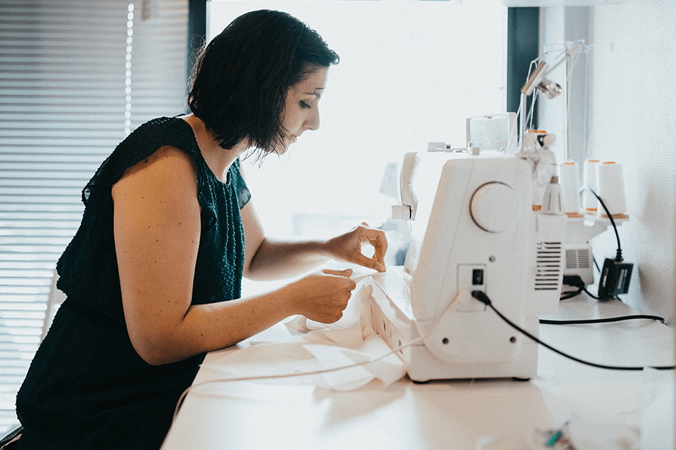 Créatrice de robes de mariée travaillant à la machine à coudre