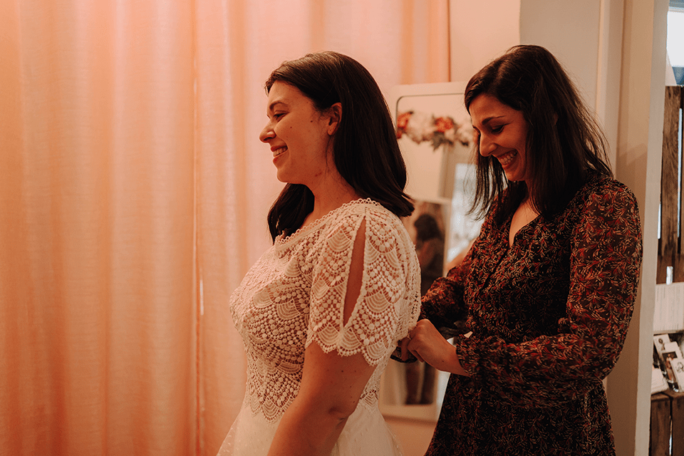 Future mariée et créatrice durant un essayage de robe