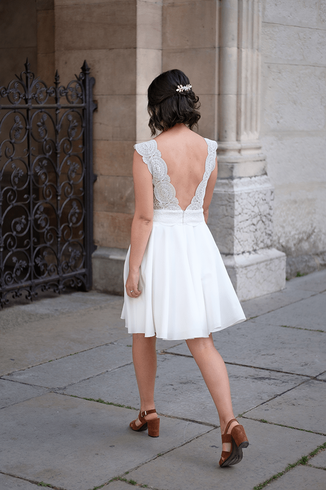 Mariée en robe courte dos nu marchant de dos