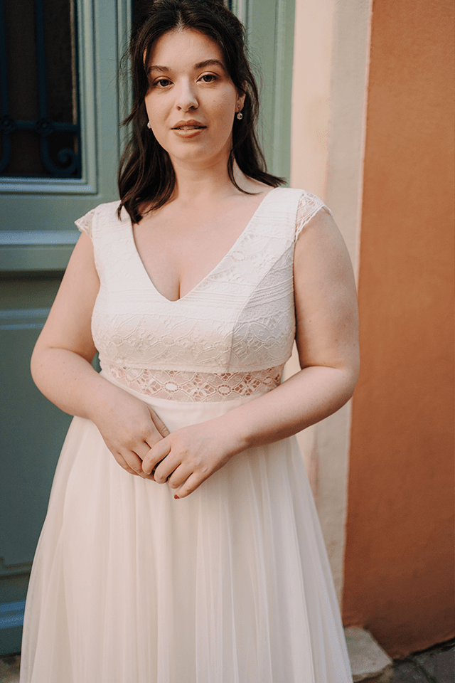 Mariée grande taille posant en extérieur
