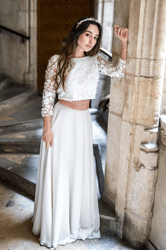Femme en robe de mariée en dentelle posant sur un escalier de château