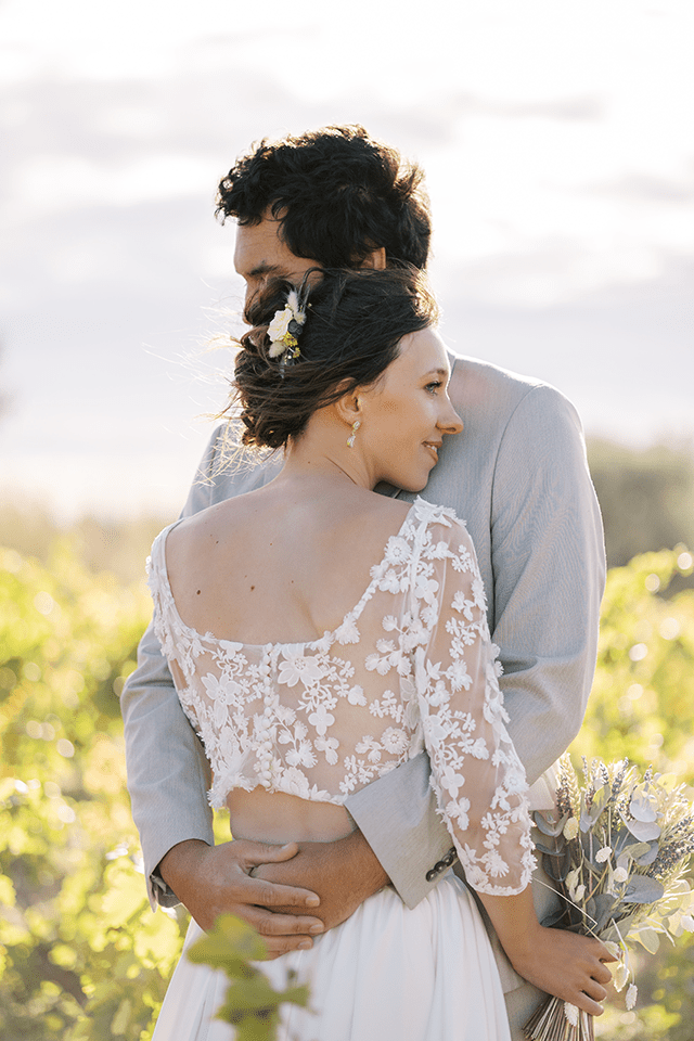 Mariée en robe transparente serrant son mari dans ses bras