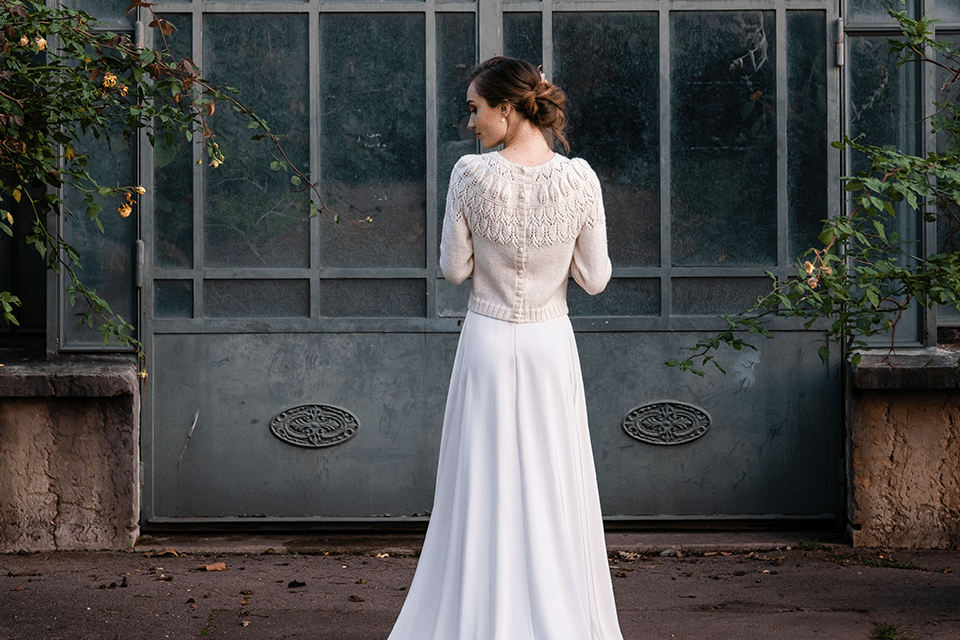Robe de mariée d’hiver avec pull assorti, photo sombre entourée de roses