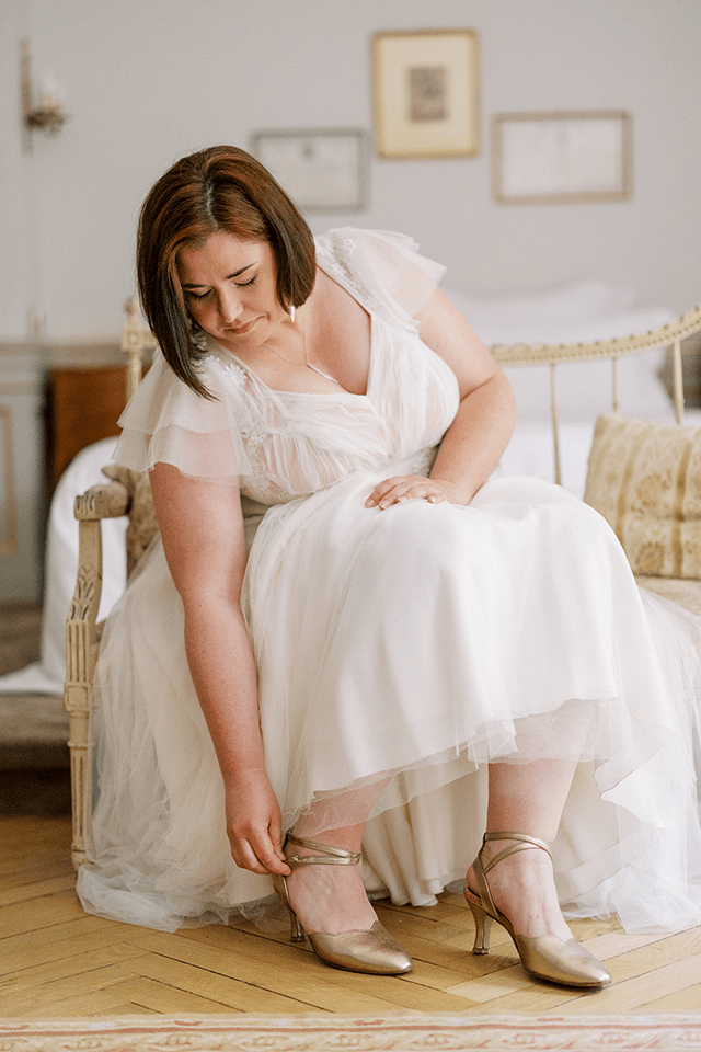 Mariée grande taille assise dans une chambre