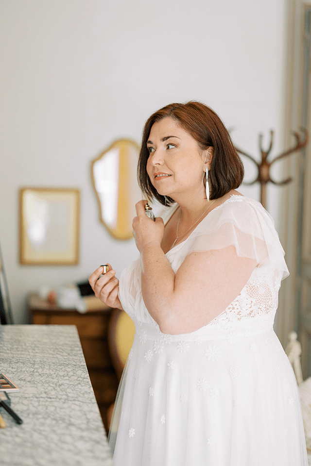 Mariée grande taille se parfumant avant la cérémonie