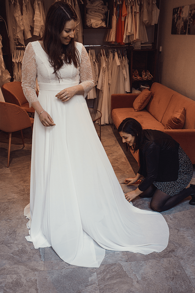 Créatrice ajustant une robe de mariée grande taille après variation de poids