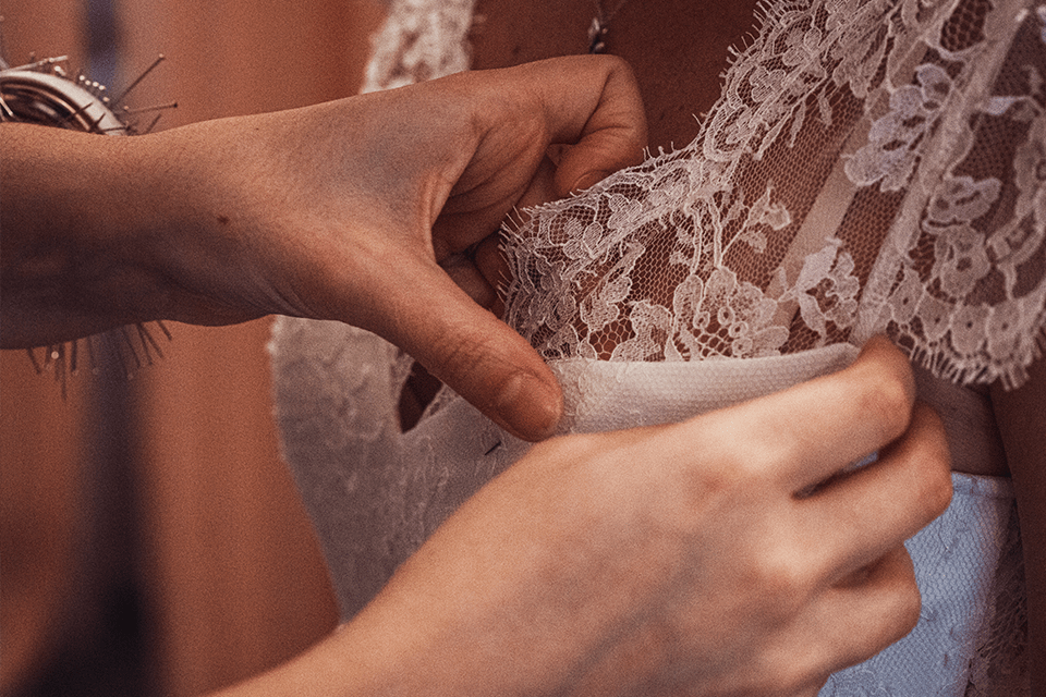 Détails couture artisanale d’une robe de mariée sur-mesure réalisée à la main avec finitions parfaites