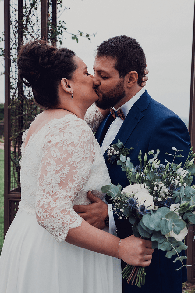 Mariée grande taille embrassant son mari lors de leur union