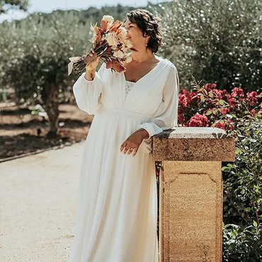 Robe de mariée grande taille sur-mesure en mousseline drapée, portée dans un jardin méditerranéen