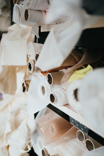 Rouleaux de tissus en stock dans l’atelier Kaa Couture pour la création de robes de mariée sur-mesure