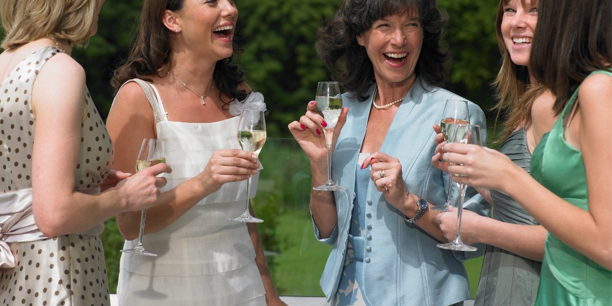 Invités profitant d’un cocktail de mariage en extérieur avec coupes de champagne