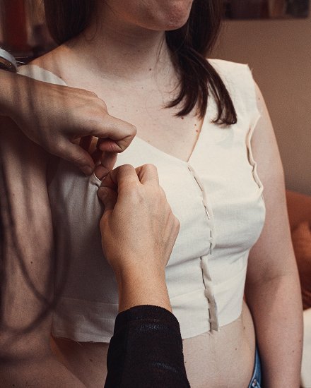 Moulage d’une toile en coton sur le buste, première étape de la création d’une robe de mariée sur-mesure chez Kaa Couture