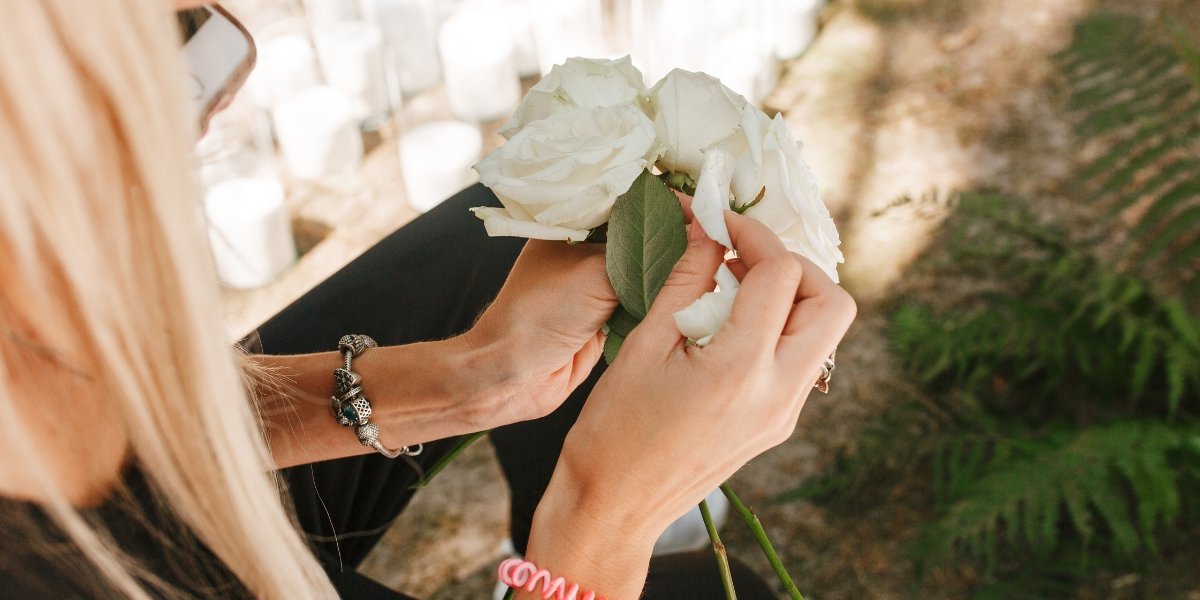 Wedding planner préparant un bouquet de mariée avec des roses blanches