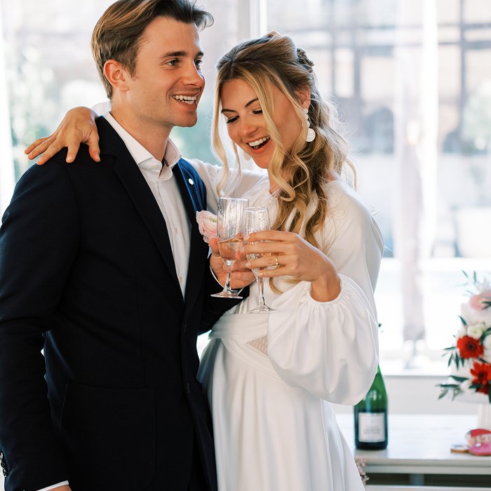 Couple de mariees trinquant avec leur verre de champagne
