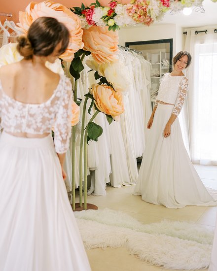 Essayage devant un miroir d'une robe de mariee en boutique