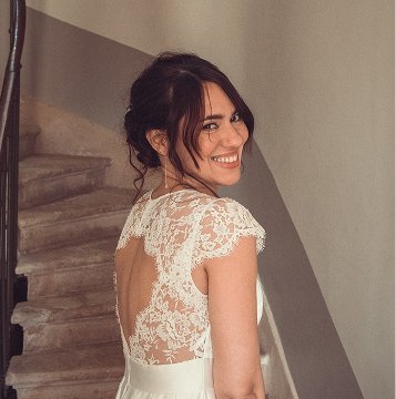 Jeune mariee dans des escalier se tournant en souriant