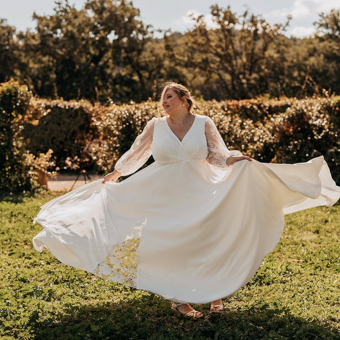 Femme ronde et grande taille en robe de mariee elegante faisant tournoyer sa robe