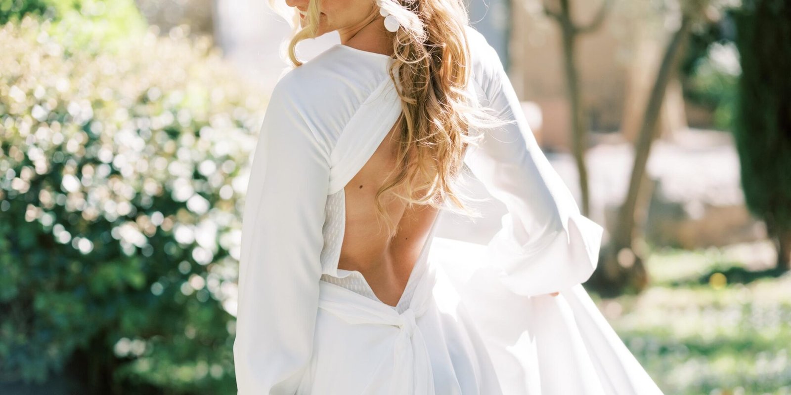 Femme blonde portant une robe de mariée sur mesure avec un dos nu